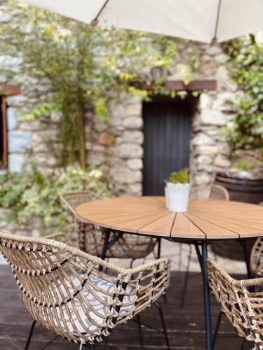 een houten tafel met twee stoelen en een tafel met een plant bij Casa Moline Apartamentos Rurales in Aneto