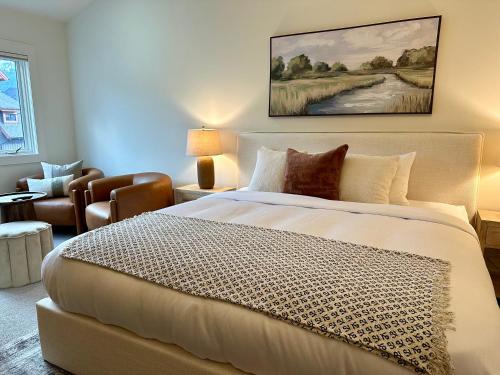 a bedroom with a large bed and a living room at Elevated Penthouse Condo hosted by Fenwick Vacation Rentals in Canmore