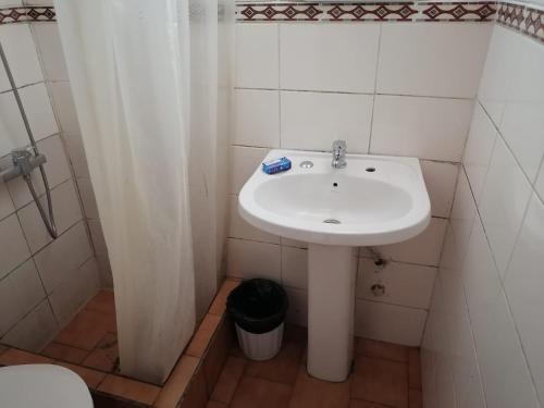 uma casa de banho com um lavatório branco e um chuveiro em Cabañas Altamira em Cobquecura