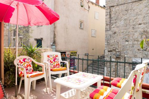 a patio with two chairs and a table and an umbrella at Apartment & Room Dubrovnik Sweet Home in Dubrovnik