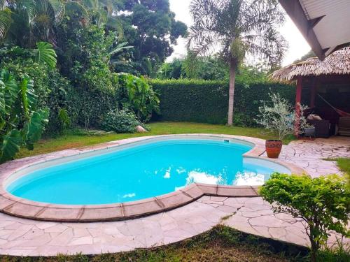 a swimming pool in a yard with a patio at Vacation house in Tahiti in Punaauia