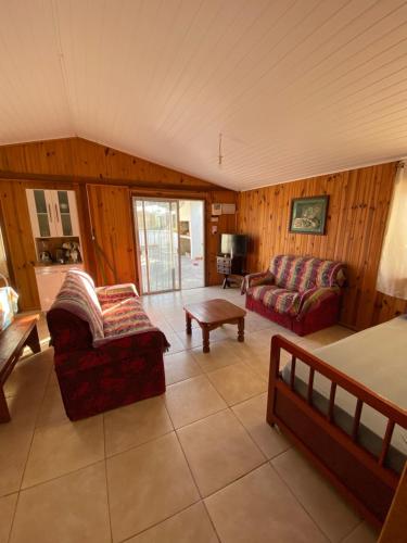 sala de estar con 2 sofás y sofá en Hermosa cabaña totalmente equipada en barra del Chuy, en Barra del Chuy