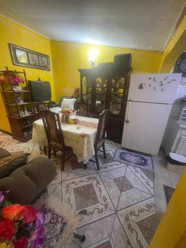 a living room with a table and a refrigerator at Jamaican J Home in Kingston