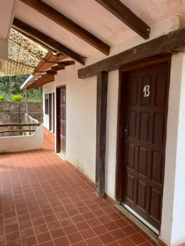 une entrée à une maison avec une porte marron dans l'établissement Hostal "Agua Dulce", à Samaipata