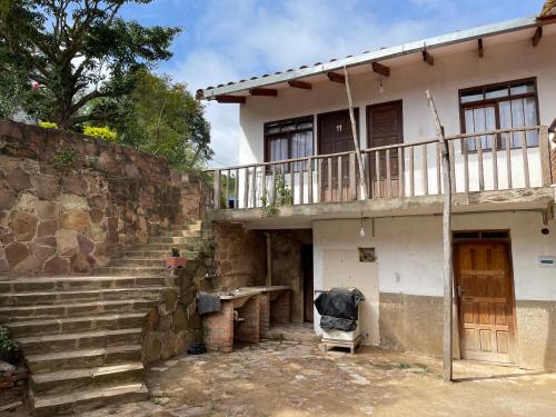 a house with a staircase leading up to it at Hostal "Agua Dulce" in Samaipata