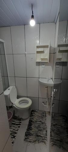 a bathroom with a toilet and a sink at kitnet aconchegante in Ubatuba