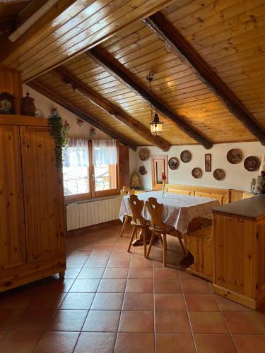 una cucina con tavolo, sedie e soffitti in legno di Stella Alpina, in Via Medail con vista incantevole sulle Alpi a Bardonecchia
