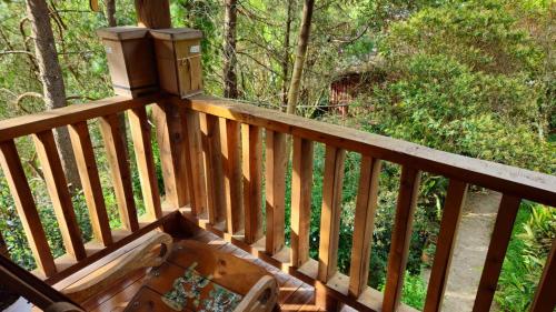 a wooden deck with a table and a box on it at Beehouse Arví Cabaña in Guarne