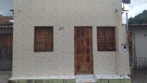 una casa con puertas de madera en un lateral en Aluga-se uma casa em Mucugê Bahia en Mucugê