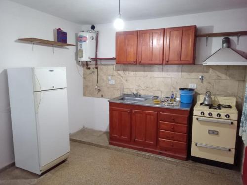 een keuken met een fornuis en een witte koelkast bij Mi Recreo in Villa Cura Brochero