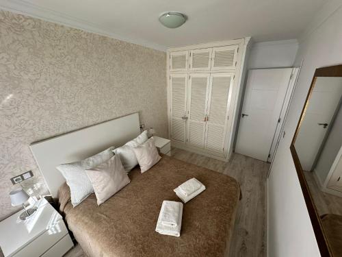 Dormitorio pequeño con cama con almohadas blancas en Apartamento Los Remedios, en Ronda