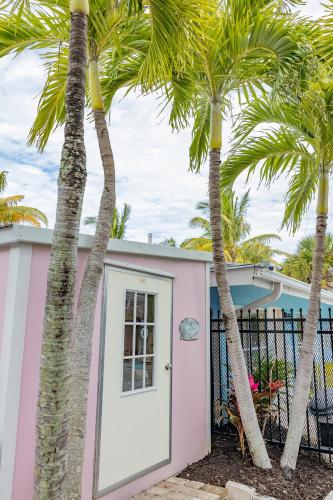 a pink house with palm trees in front of it at Siesta Key Beachside Villas in Sarasota