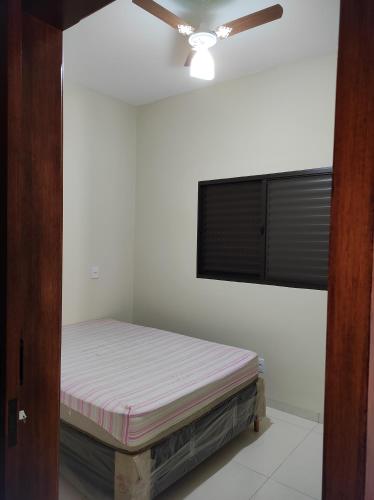 uma cama num quarto com uma ventoinha de tecto em Rest time em Olímpia