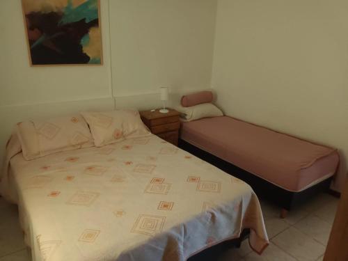 ein kleines Schlafzimmer mit einem Bett und einem Nachttisch in der Unterkunft Casa La Nona in Estancia Vieja