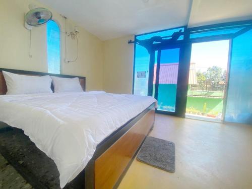 a bedroom with a bed and a large window at Plankton Bungalow and Camping in Koh Rong Island