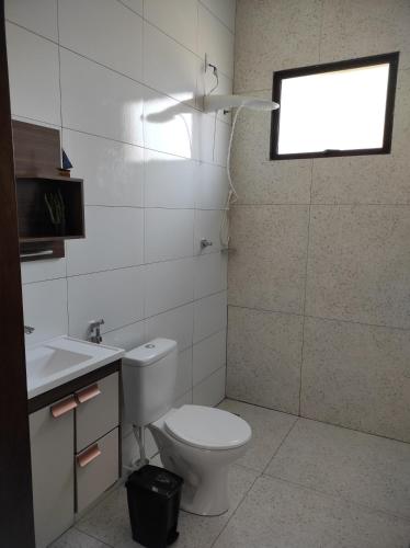 uma casa de banho com um WC branco e uma janela em Rest time em Olímpia