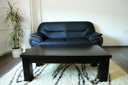 a black leather couch and a coffee table in a living room at Apartment Travego II in Osijek