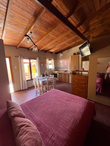 a bedroom with a large bed and a kitchen at CABAÑAS MECHI in Mar del Plata