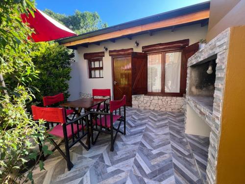 a patio with a table and chairs and a house at CABAÑAS MECHI in Mar del Plata