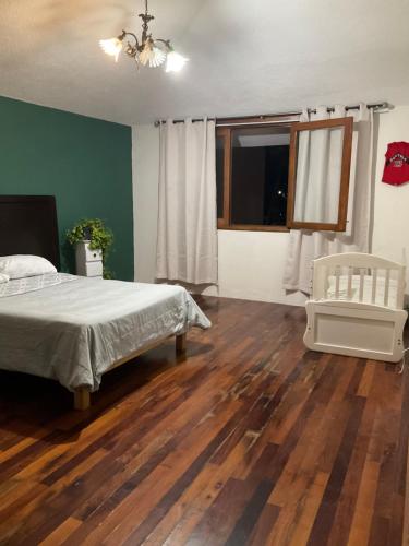um quarto com uma cama e piso em madeira em Casa Juan Gabriel em El Castillo