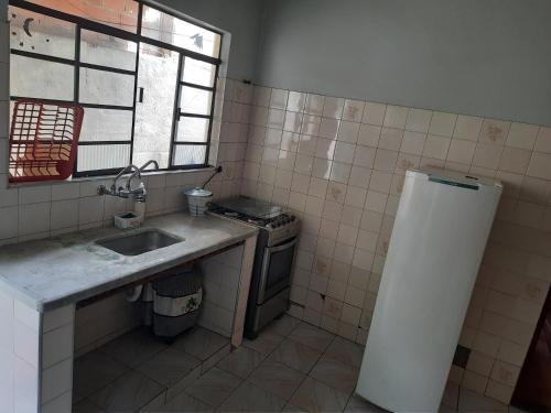 a small kitchen with a sink and a stove at Hostel Sancris 2 in São José dos Campos