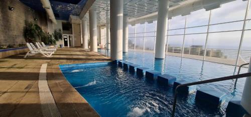 a large swimming pool in a building with windows at Reñaca-Cochoa Vista Mar-3D -funicular directo playa in Viña del Mar