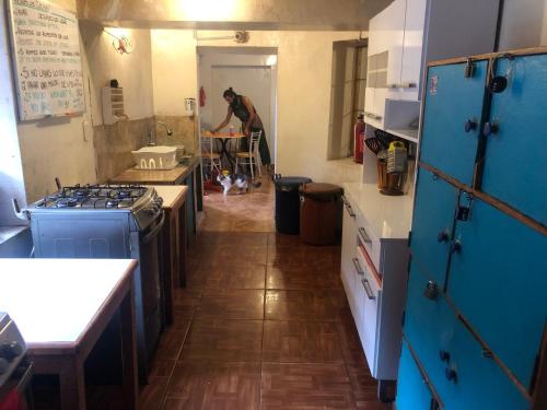 皮薩克的住宿－Intihuatana Hostel，一间厨房,内配蓝色橱柜,后面有一个人