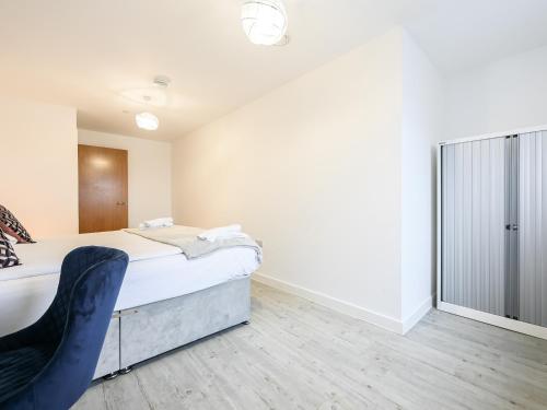 a bedroom with a bed and a chair in it at Stylish & Spacious Salford Quays one bedroom high floor apartment with balcony in Manchester