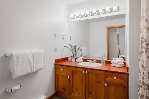 ein Bad mit einem Waschbecken und einem Spiegel in der Unterkunft Blueberry Hill Premium Area in Whistler