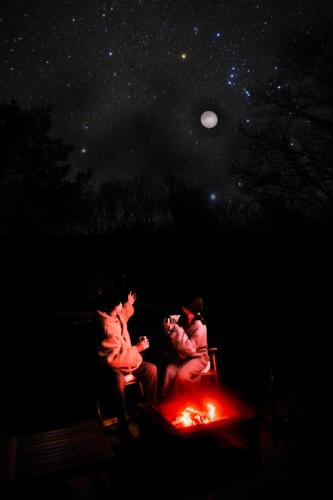 Mukaitanouraにあるしまなみ宿sagiの夜、火の周りに座っている人々のグループ