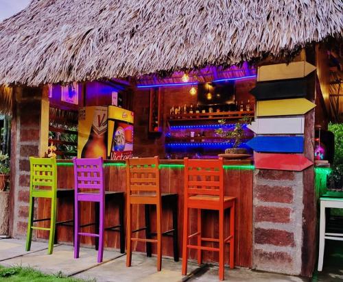 a bar with colorful chairs in front of a bar at Hostal Casa Mauro in Moyogalpa