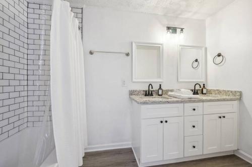 - une salle de bains blanche avec deux lavabos et une douche dans l'établissement Cozy Kennesaw Apartment Close to KSU with EV Plug In, à Kennesaw