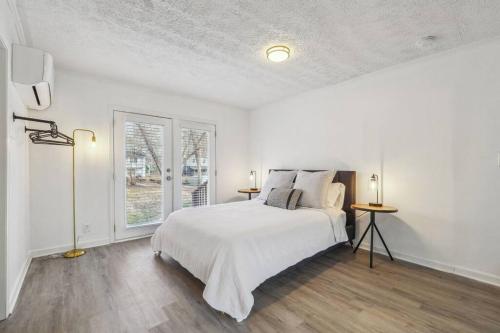 - une chambre blanche avec un lit et une fenêtre dans l'établissement Cozy Kennesaw Apartment Close to KSU with EV Plug In, à Kennesaw
