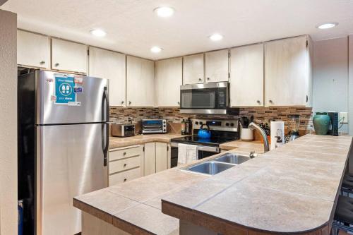 a kitchen with a stainless steel refrigerator and cabinets at Giant Steps #43 W Hot Tub, Sauna, And Game Room! in Brian Head
