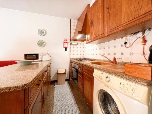a kitchen with a washing machine and a sink at Refúgio do Vidoeiro in Geres