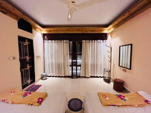 a bedroom with two beds and a large window at Eco Divine Beach Resort- Saint Martin in Jaliapāra