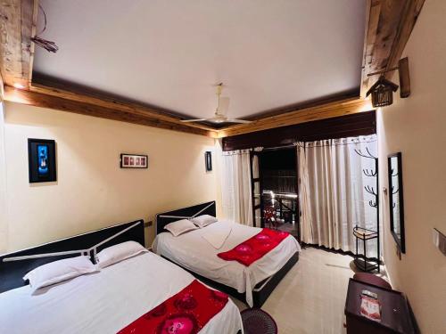 a bedroom with two beds with red pillows at Eco Divine Beach Resort- Saint Martin in Jaliapāra