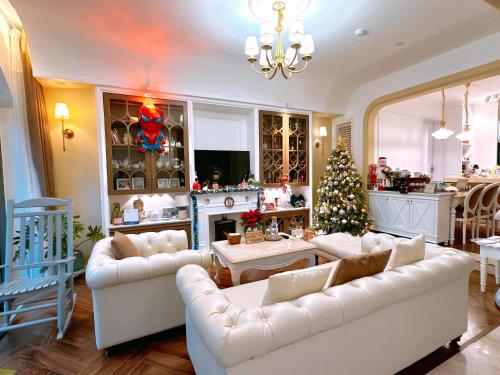 a living room with white couches and a christmas tree at Moon Homestay in Thôn Kim Long (1)