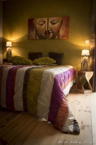 a bed with a colorful blanket on top of it at Mer et Sable B&B in Ville-Pommeroeul