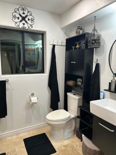a bathroom with a toilet and a sink and a mirror at A Luxury Master Bedroom in a Condo in Los Angeles