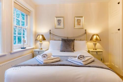 a bedroom with a bed with towels on it at Cozy Coach House Nr Golf & Beach in Broadstairs