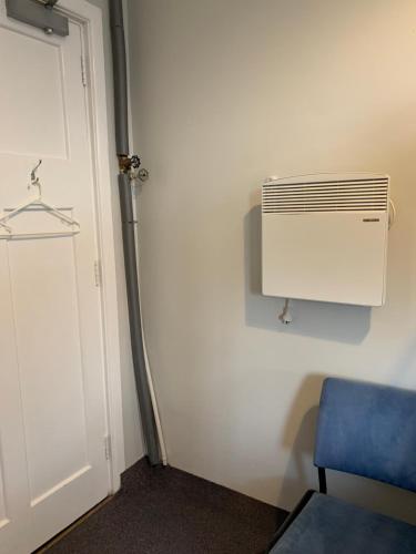 a room with a heater and a blue chair at Thomas's Catlins Lodge and Camp Ground in Owaka