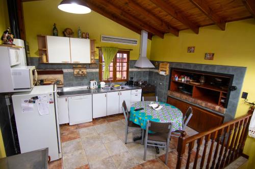 cocina con electrodomésticos blancos, mesa, mesa y sillas en Alojamiento Del Bosque en Ushuaia