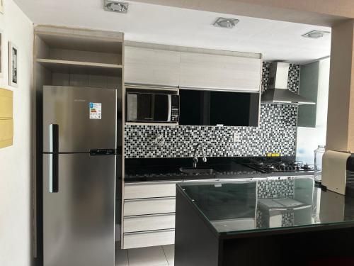 a kitchen with a stainless steel refrigerator and a counter at Rio Centro Barra da Tijuca in Rio de Janeiro