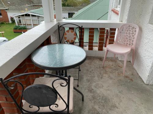 a table and a chair sitting on a balcony at Thomas's Catlins Lodge and Camp Ground in Owaka