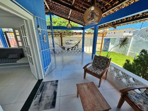 ein Wohnzimmer mit einem Stuhl und einem Tisch in der Unterkunft Casa Coroa Grande! A Sua Casa de Praia em São José in São José da Coroa Grande