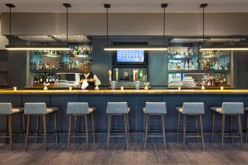a bar in a restaurant with blue walls and stools at Fort Lauderdale Marriott North in Fort Lauderdale