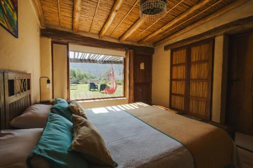 a large bed in a room with a large window at Aguacanto Cabañas in Tilcara