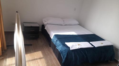 Un pequeño dormitorio con una cama con toallas. en Apartamento Eje Cafetero, en Armenia