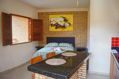 a kitchen with a table and a bed in a room at Pousada Flor da Serra in Mulungu